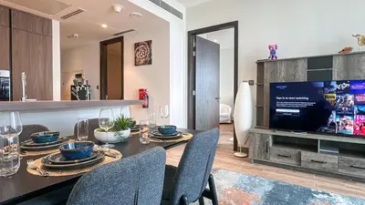 a dining room with a table with chairs and a television at Exclusive 1BR in Marina Gate Dubai Marina - 46AB03 in Dubai