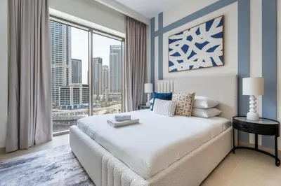 a bedroom with a large bed and a large window at GuestReady - Blue Bliss l 2Bed l Lagoon Escape in Dubai
