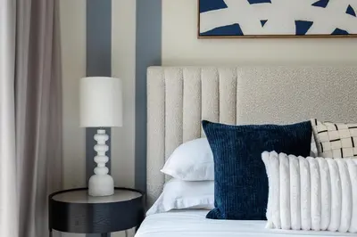 a bed with a blue pillow and a lamp on a table at GuestReady - Blue Bliss l 2Bed l Lagoon Escape in Dubai
