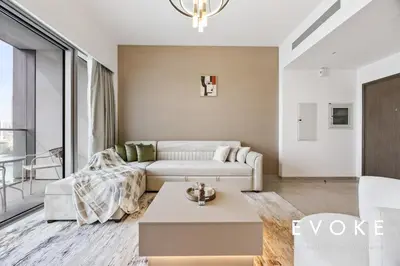 a living room with a couch and a table at Grande Residence Burj View 2 BR by Evoke Luxury in Dubai