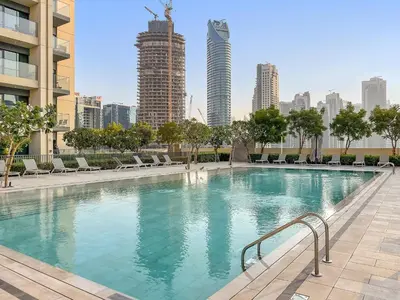 a large swimming pool in a city with tall buildings at Luxury 2BR with Burj Khalifa Views l Near Dubai Mall in Dubai