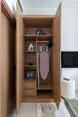 a room with a closet with a bed and a tv at Cozy Studio in JVC Dubai in Dubai