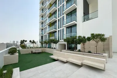 an apartment patio with benches and a green lawn at Cozy Studio in JVC Dubai in Dubai
