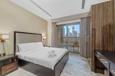 a hotel room with a bed and a balcony at Modern Studio at Elite Downtown Residence in Dubai