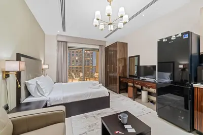 a hotel room with a bed and a television at Modern Studio at Elite Downtown Residence in Dubai