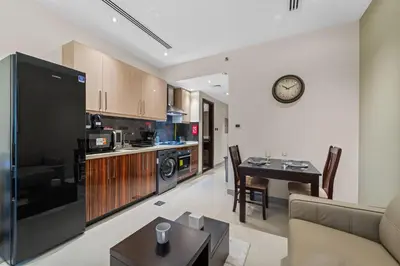 a kitchen and living room with a couch and a table at Modern Studio at Elite Downtown Residence in Dubai