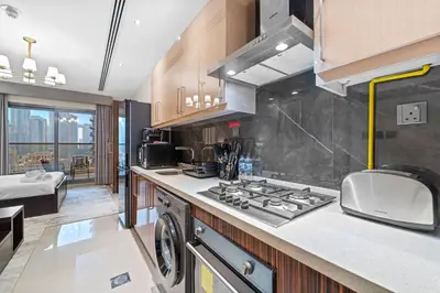 a kitchen with a stove top oven next to a sink at Modern Studio at Elite Downtown Residence in Dubai