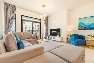 a living room with a couch and a tv at Chic Apartment with Balcony & Views in Dubai