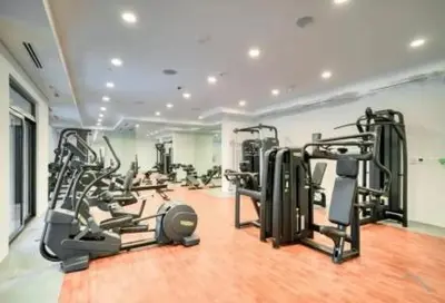 a gym with several tread machines in a room at Chic Apartment with Balcony & Views in Dubai