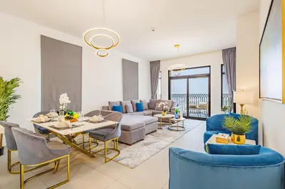 a living room with a couch and a table and chairs at Chic Apartment with Balcony & Views in Dubai