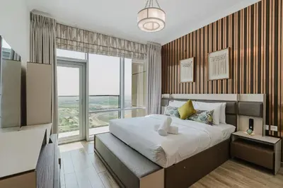 a bedroom with a large bed and a large window at RH-Luxury 1BR Apt in Al Habtoor City with beautiful Canal View in Dubai