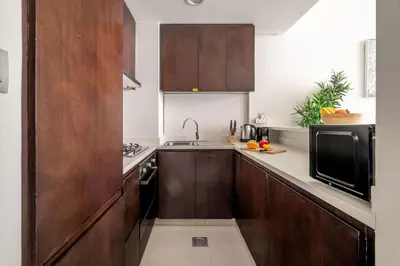 a kitchen with wooden cabinets and a sink at DAYF-MER Stylish 1Bed in central location Business Bay in Dubai