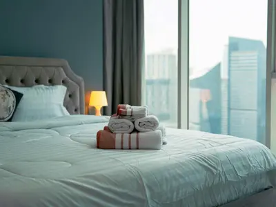 a hotel room with a bed with towels on it at Continental Tower Stylish 2BR and Private Hot Tub in Dubai