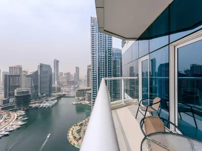 a balcony with chairs and a view of a river at Continental Tower Stylish 2BR and Private Hot Tub in Dubai