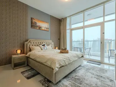 a bedroom with a large bed and a large window at Continental Tower Stylish 2BR and Private Hot Tub in Dubai
