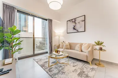 a living room with a couch and a table at Near Circle Mall And Parks, Easy Access to Al Khail Road And Close to RTA Bus Stop, Lucky Residences, JVC by Deluxe Holiday Homes in Dubai