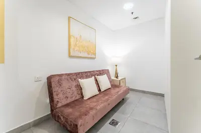 a couch with two pillows sitting in a room at Near Circle Mall And Parks, Easy Access to Al Khail Road And Close to RTA Bus Stop, Lucky Residences, JVC by Deluxe Holiday Homes in Dubai