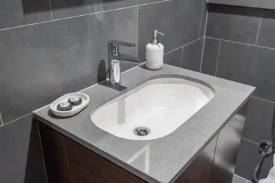 a bathroom sink with a soap bottle on a counter at Modern 1BHK Bunk Beds and Sofa Bed By Czechin in Dubai