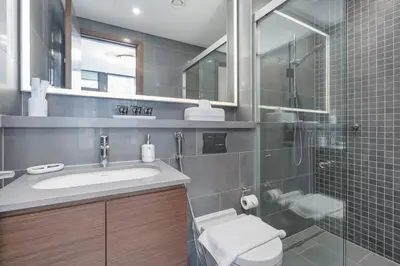 a bathroom with a toilet and a sink and a shower at Modern 1BHK Bunk Beds and Sofa Bed By Czechin in Dubai