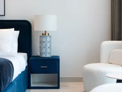 a bedroom with a blue nightstand with a bed and a chair at Private Pool Paradise Villa! Dubai Mall in a Flash! Complimentary Full Mid-Stay Refresh for 1 week stay in Dubai