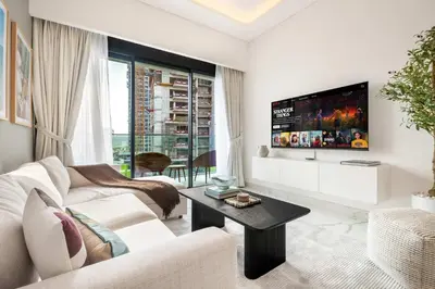 a living room with a white couch and a tv at AirDXB - Meydan Apartment sleeps 4 in Great Location in Dubai