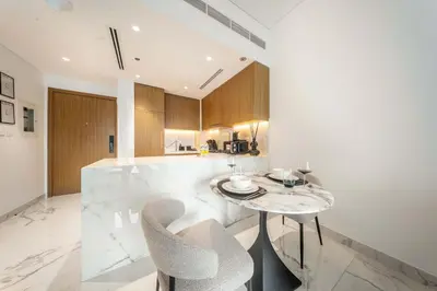 a kitchen with a table and chairs and a counter at AirDXB - Meydan Apartment sleeps 4 in Great Location in Dubai