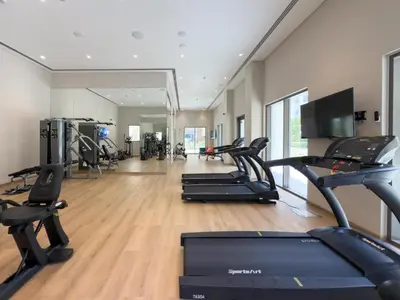 a gym with several treadmills and cardio machines at GuestReady - Creek View l 2Bed l Lagoon Escape in Dubai