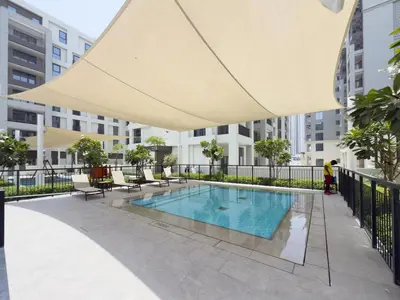 a large umbrella over a swimming pool in a building at GuestReady - Creek View l 2Bed l Lagoon Escape in Dubai