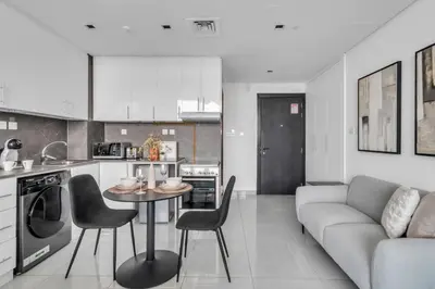 a kitchen and living room with a table and chairs at GuestReady - Stylish l High Floor Studio in Dubai