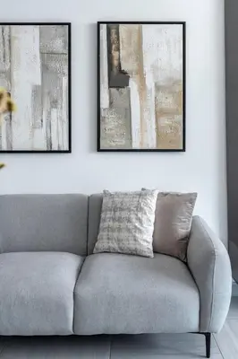 a couch in a living room with two pictures on the wall at GuestReady - Stylish l High Floor Studio in Dubai