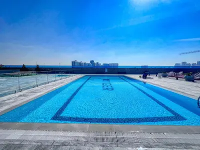 a large swimming pool with blue water at GuestReady - Stylish l High Floor Studio in Dubai