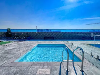 a swimming pool with blue water in front of a building at GuestReady - Stylish l High Floor Studio in Dubai