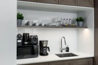 a kitchen counter with a sink and a microwave at Waves - Luxury Beachfront Escape - Skyline & Sea Views in Dubai