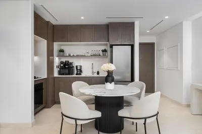 a dining room with a table and white chairs at Waves - Luxury Beachfront Escape - Skyline & Sea Views in Dubai