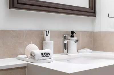 a bathroom counter with a sink with a towel at Waves - Luxury Beachfront Escape - Skyline & Sea Views in Dubai