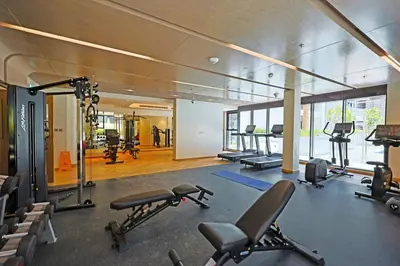 a gym with several treadmills and machines in it at Spacious Luxury Escape - Modern Comfort in Riviera in Dubai