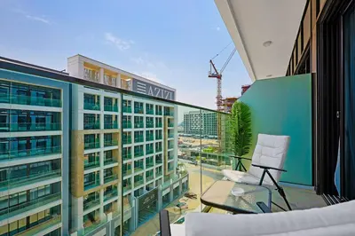 a balcony with a chair and a building at Spacious Luxury Escape - Modern Comfort in Riviera in Dubai
