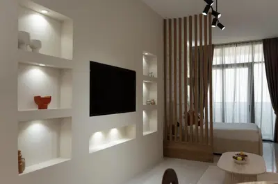 a white living room with a television and a bed at Apartment Studio Blue Wave in Dubai