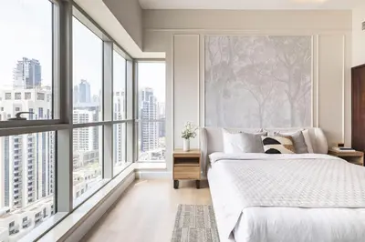 a bedroom with a bed and large windows at The Boulevard Central Suite Near Burj Khalifa in Dubai