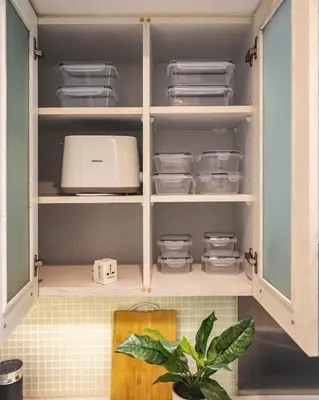 a kitchen cabinet filled with dishes and a appliance at The Boulevard Central Suite Near Burj Khalifa in Dubai