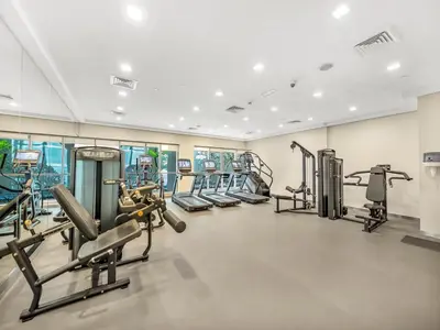 a gym with several treadmills and cardio machines at The Boulevard Central Suite Near Burj Khalifa in Dubai