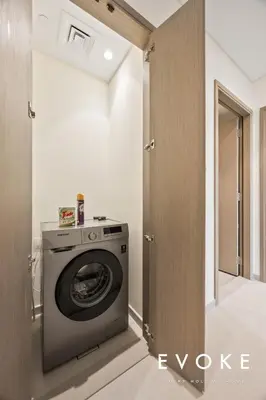 a laundry room with a washer and dryer at Grande 2BR Balcony Burj & Fountain Views by Evoke in Dubai