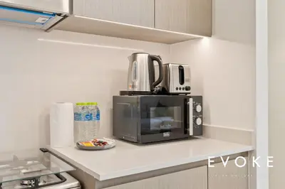 a microwave sitting on top of a kitchen counter at Grande 2BR Balcony Burj & Fountain Views by Evoke in Dubai