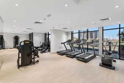 a gym with treadmills and elliptical machines at Charming 1-Bedroom Close to Downtown in Dubai