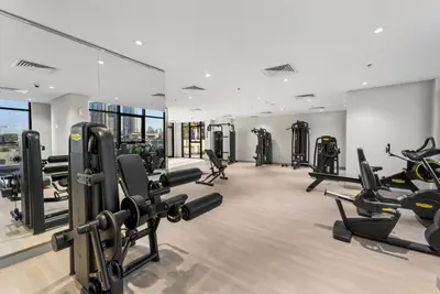 a gym with a lot of treadmills and ellipticals at Charming 1-Bedroom Close to Downtown in Dubai
