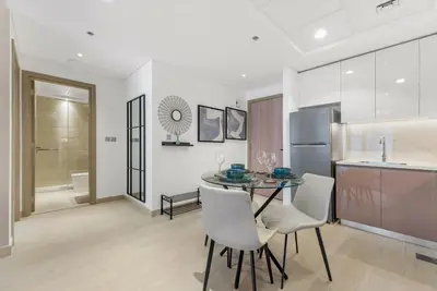 a kitchen and dining room with a table and chairs at 1 Bedroom Royal Dubai Stay in Dubai