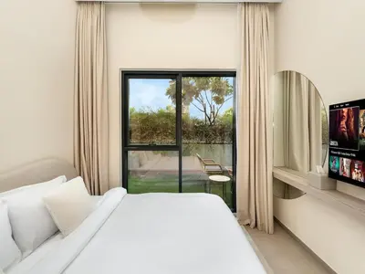 a white bedroom with a bed and a window at Dubai Hills Retreat Garden, Pool & Park Access in Dubai