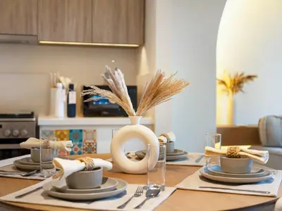 a dining room table with plates and cups on it at Dubai Hills Retreat Garden, Pool & Park Access in Dubai