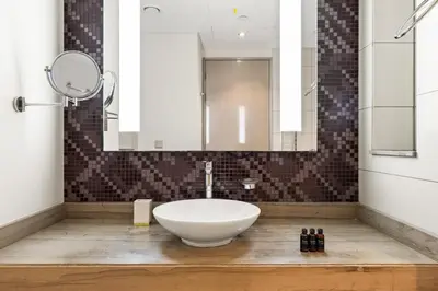 a bathroom with a white sink and a mirror at BLVD - Damac Paramount with Burj Khalifa View in Dubai