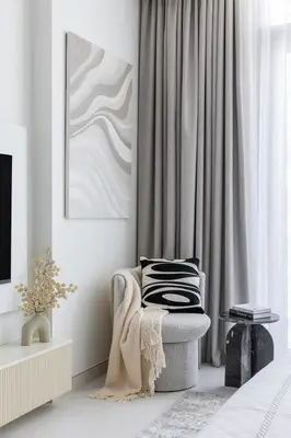 a white room with a chair and a picture at Designer 3BR Lagoon Views Gym District One in Dubai